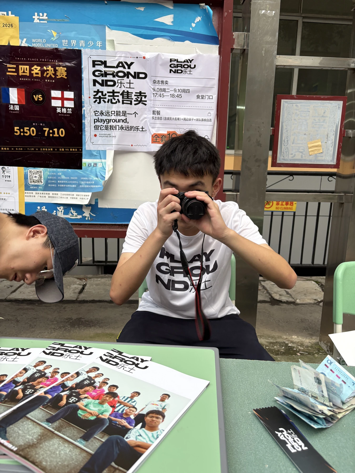 Teng Long holding a camera at a PLAYGROUND magazine display